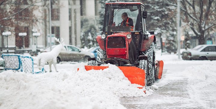 a man driving the tractor removing the snow