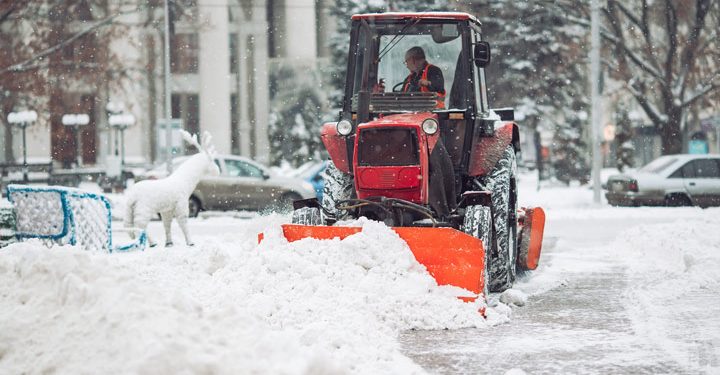 a man driving the tractor removing the snow